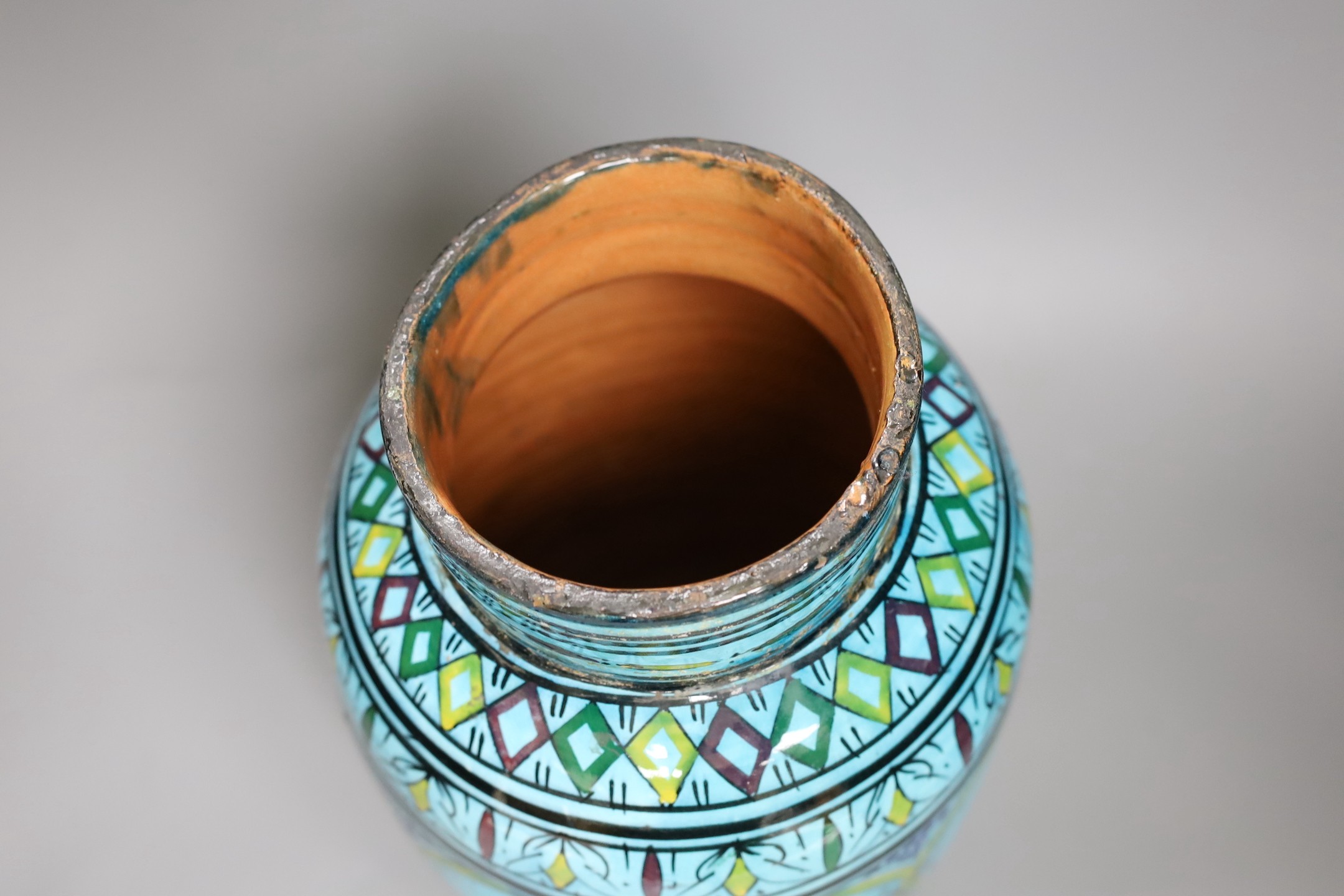 A large Persian ovoid painted terracotta vase, 34cm
